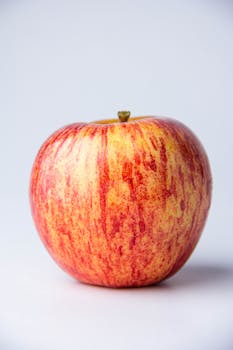 Close-up of a fresh red apple on a white background, perfect for food photography.